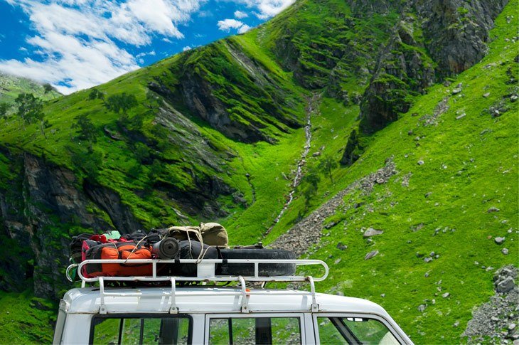 Camping Tents And Equipment On Car Trunk In Mountains