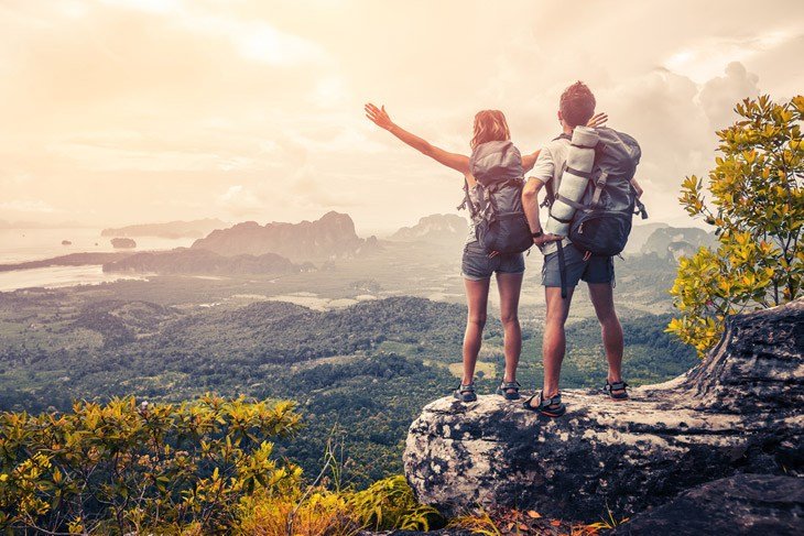 Hiker Couple With Backpacks Relaxing On Top Of A Mountain