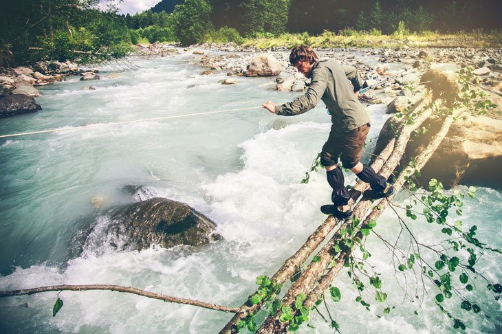 Man Traveler Crossing Over River On Outdoor Woods